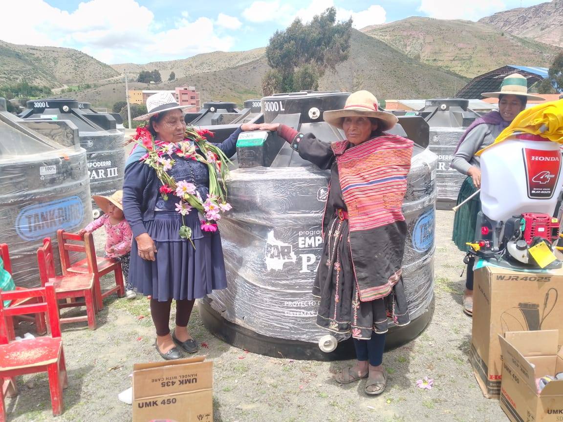 Beneficiarias junto a los tanques de agua entregados por el Gobierno. Foto: Programa Empoderar